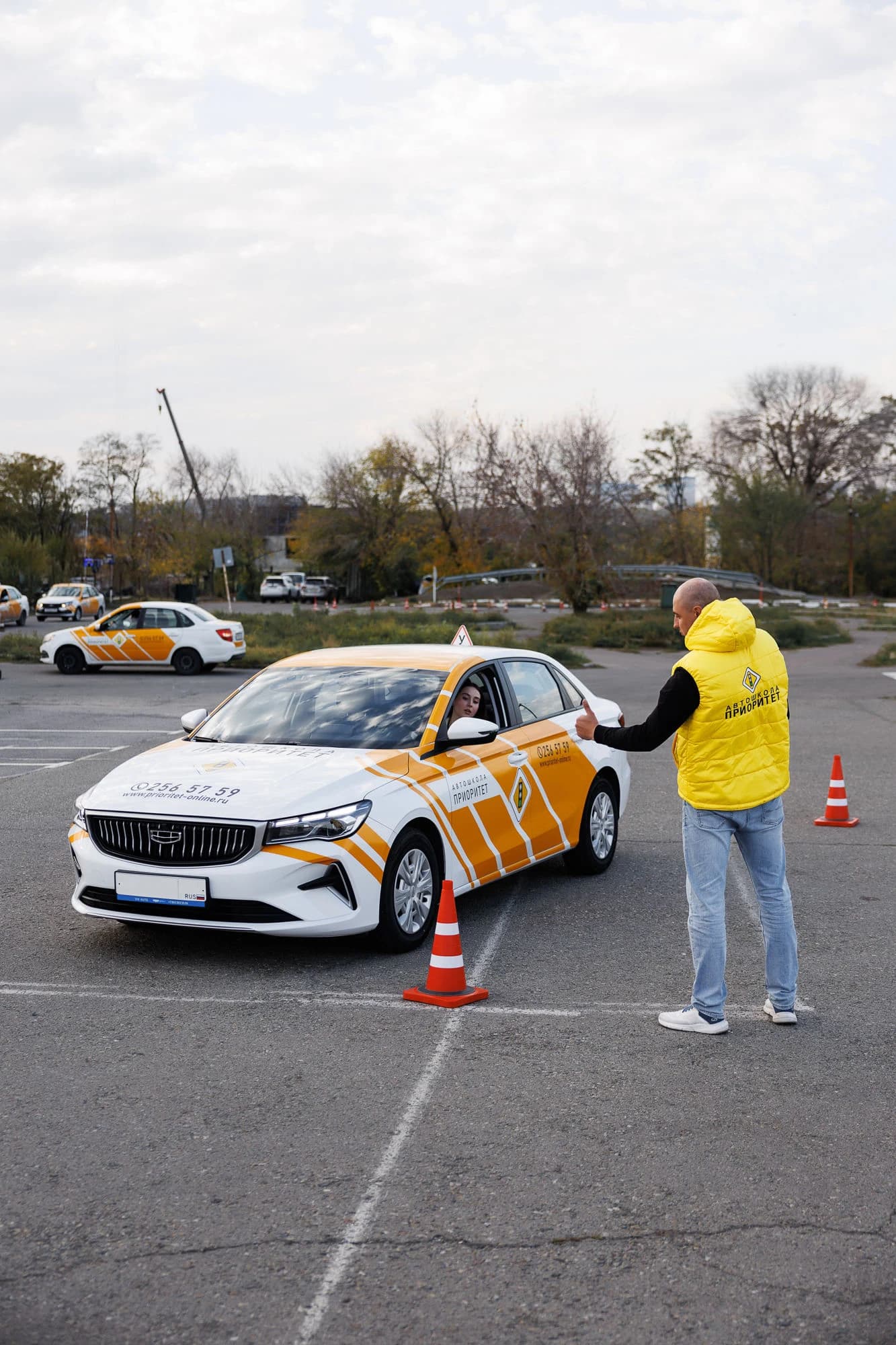 Инструктор направляет ученицу на автодроме автошколы Приоритет
